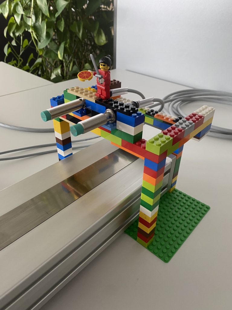 Detailed shot of a holder with Lego blocks. The Lego blocks are colorful and a Lego man with a pizza in his hand stands on the building just for fun.