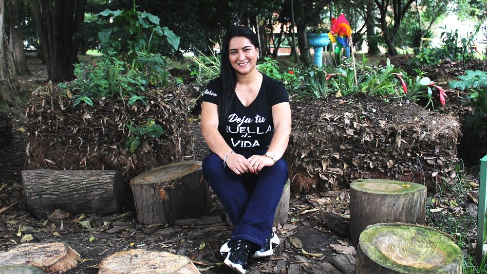 CEIBA MUNAY: In her free time, Marcella (Sales Manager at Pepperl+Fuchs) works with her foundation for the two main aspects of education and nature. Marcella is sitting outside in tne nature.