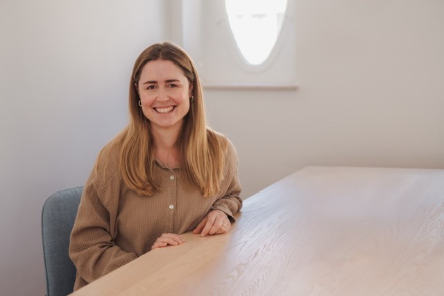 Family-friendly working at Pepperl+Fuchs: portrait picture of Annette. She is sitting at a table.
